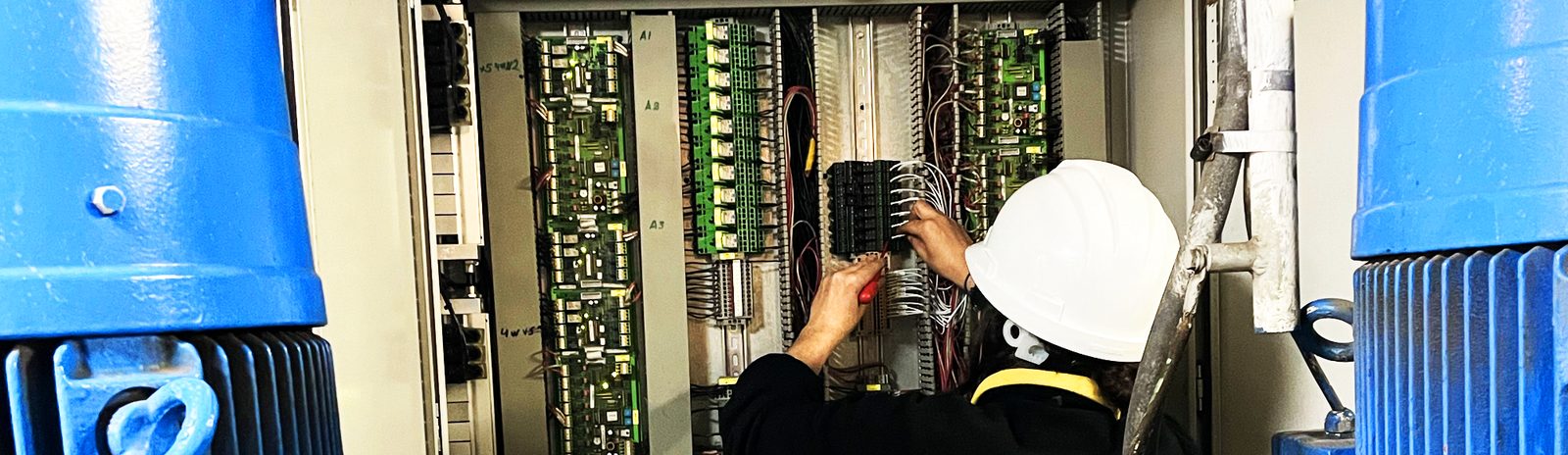 Technicien en électricité maritime travaillant dans un panneau électrique